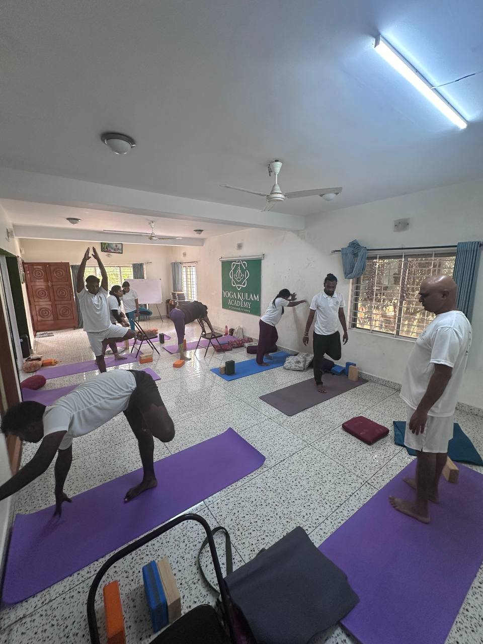 Students practicing yoga at Yogakulam Academy